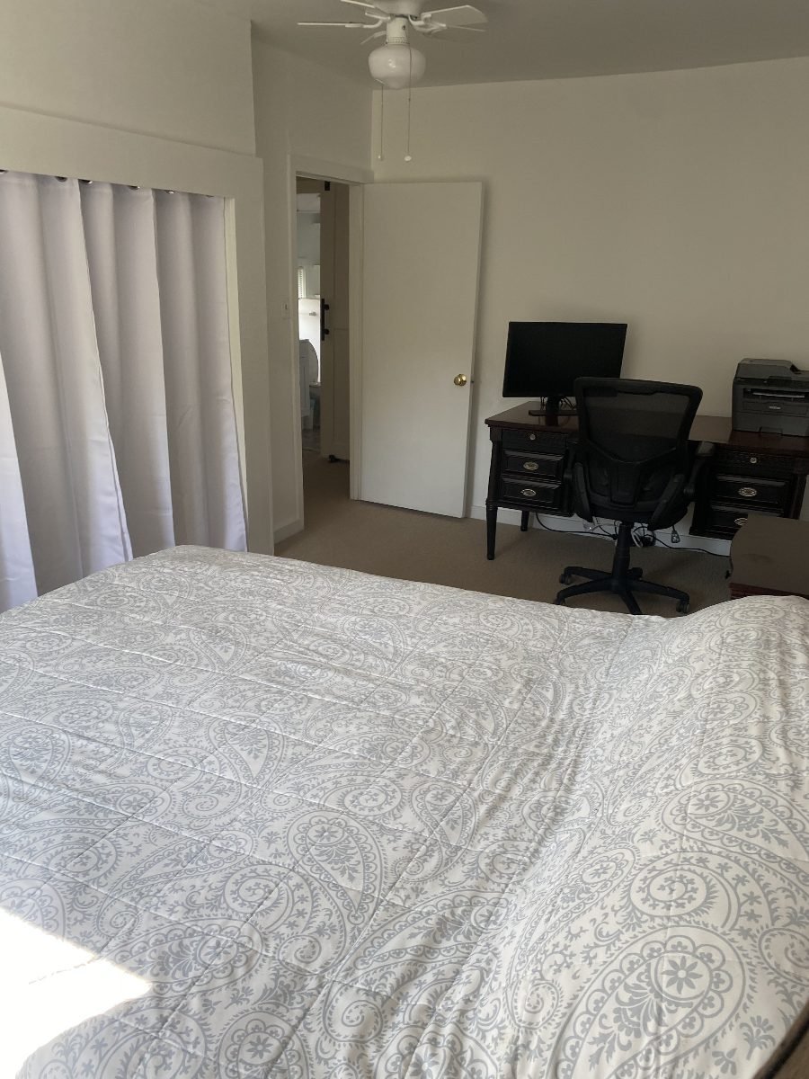 Primary bedroom with queen bed and workspace